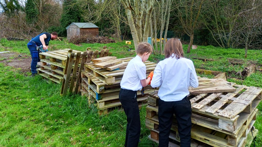 young people making an insect house out of pallets
