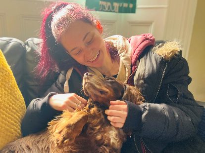 smiling young woman cuddling a dog