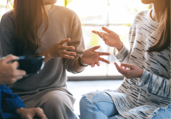 Two adults sat together talking over coffee.